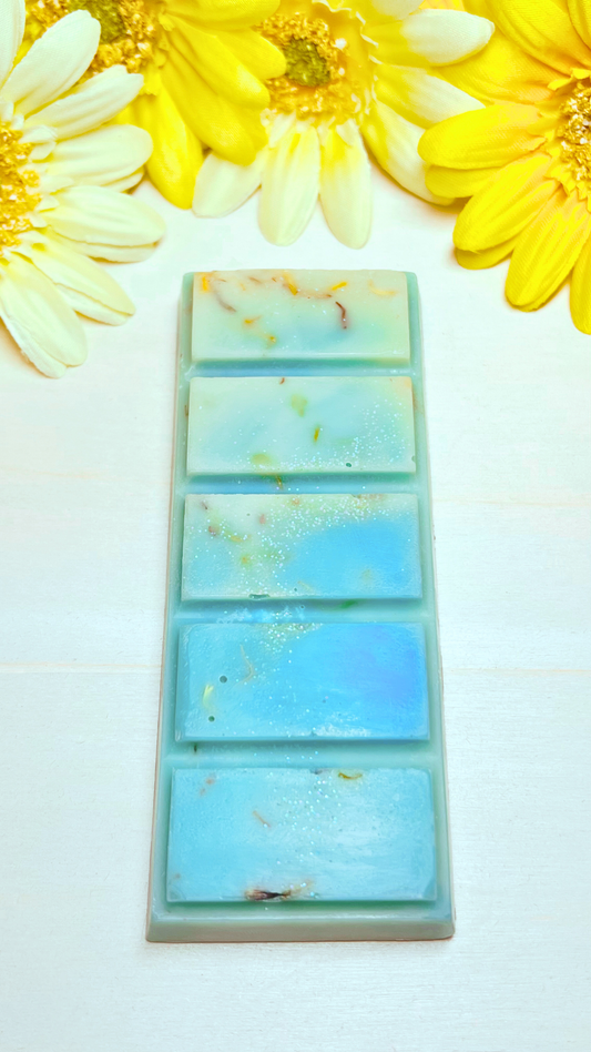 Blue and yellow wax snap bar with biodegradable glitter and flower petals.