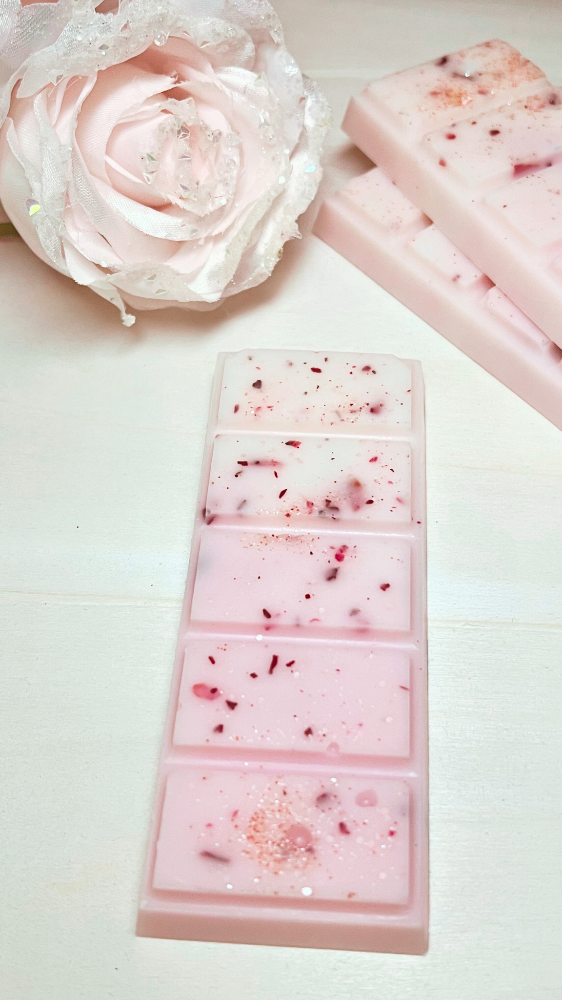 Pink and white wax snap bar with sparkly biodegradable glitter and rose petals.
