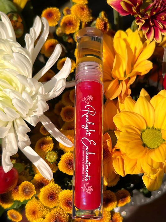 Red lip gloss with the branding "Roselight Enchantments" against a floral background